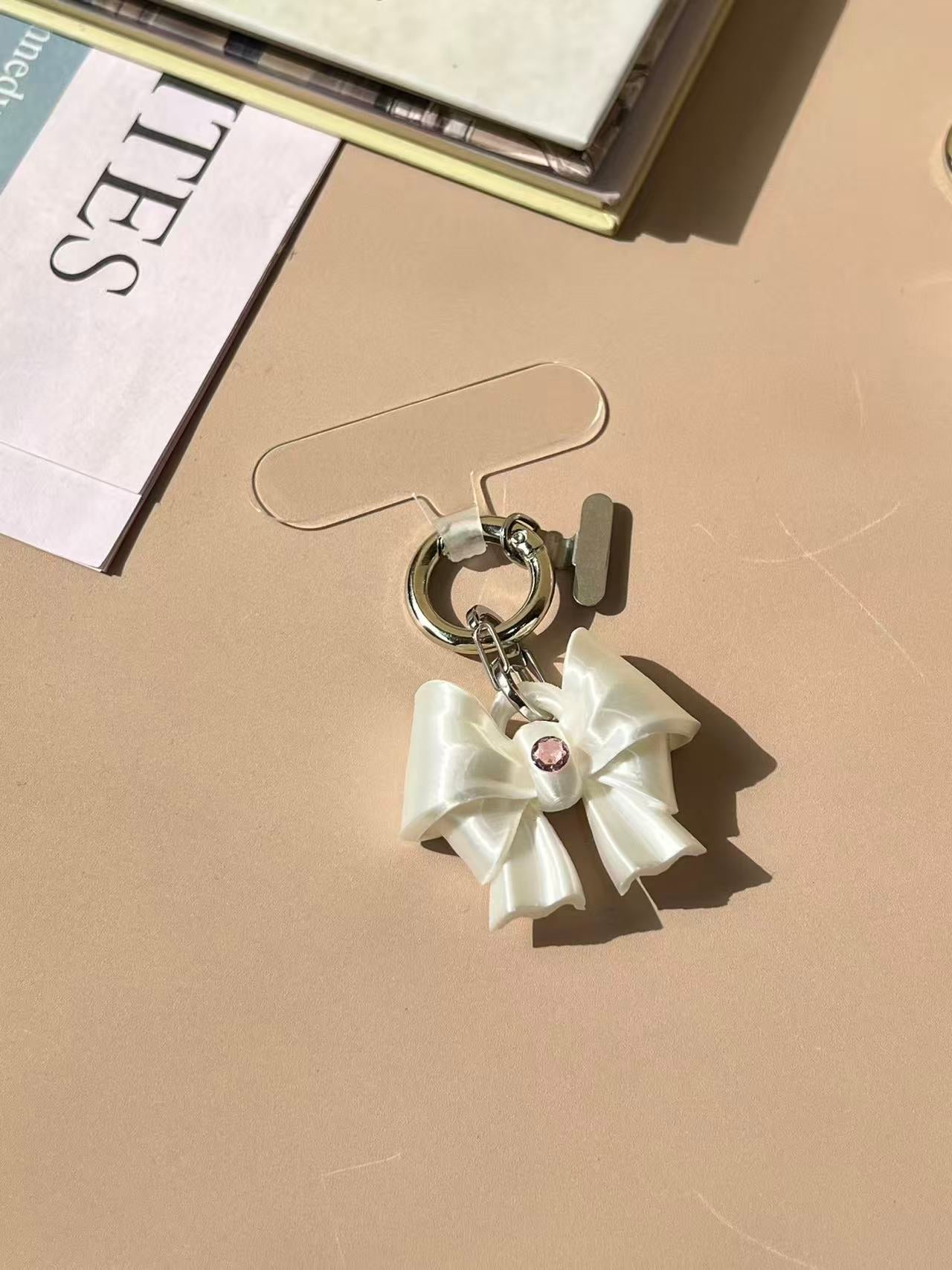 Bow Phone Charm in silk white and silk pink with cubic zirconia by UNICOLOOM