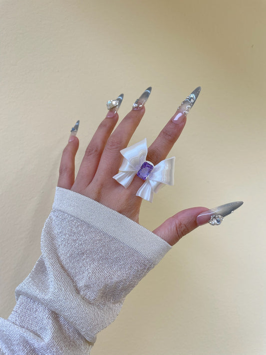 Silk White Ribbon Bow Ring with purple cubic zirconia on display by UNICOLOOM